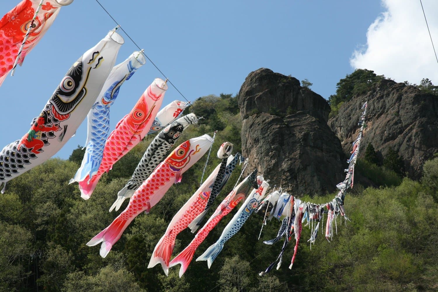 Koinobori carp streamers flying by a rocky crag at Takeyama, Gunma