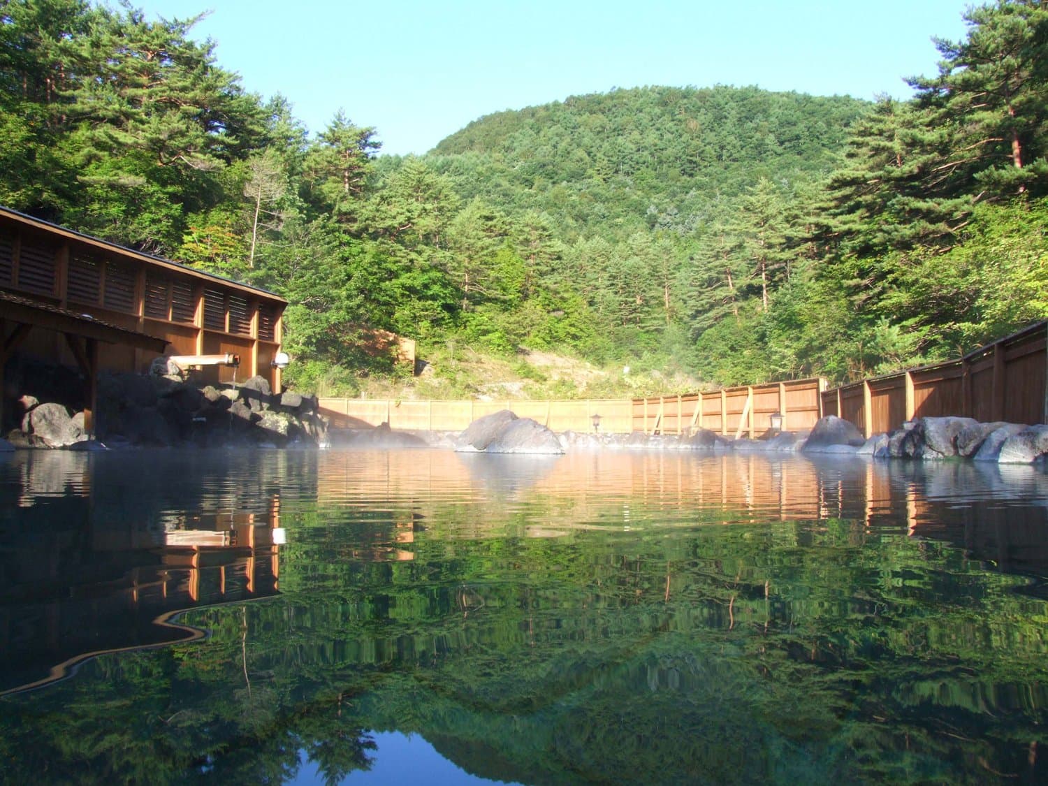 The open-air Sainokawara Rotenburo bath surrounded by forest in Kusatsu